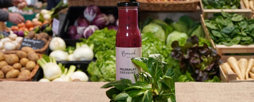 Flasche Dressing vor frischem Gemüse