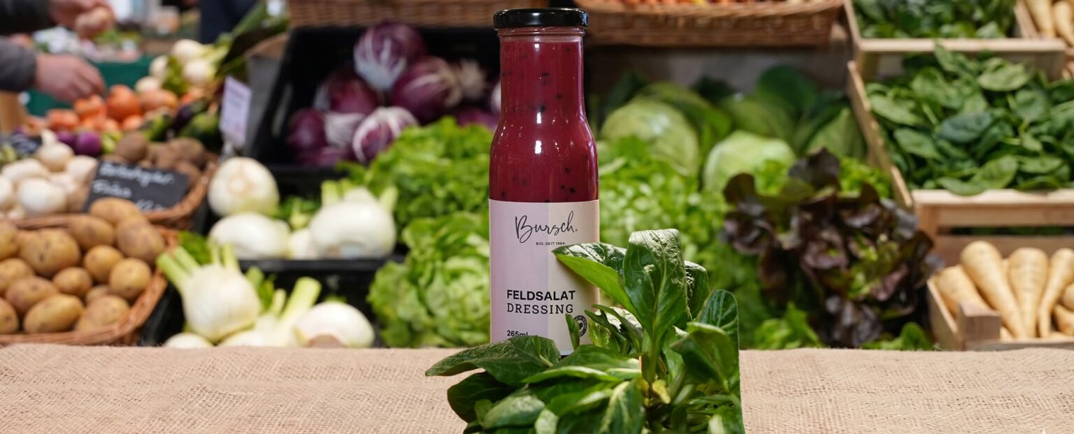 Flasche Dressing vor frischem Gemüse