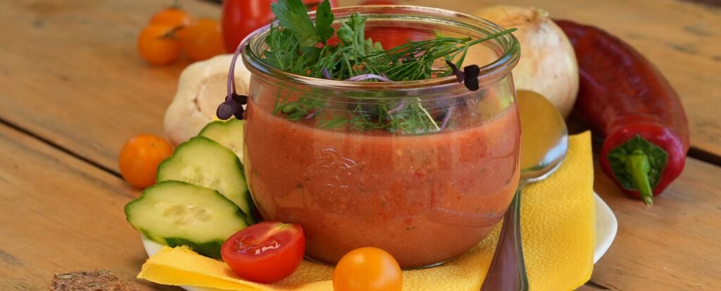 Ein Glas mit Gazpacho und Gemüse