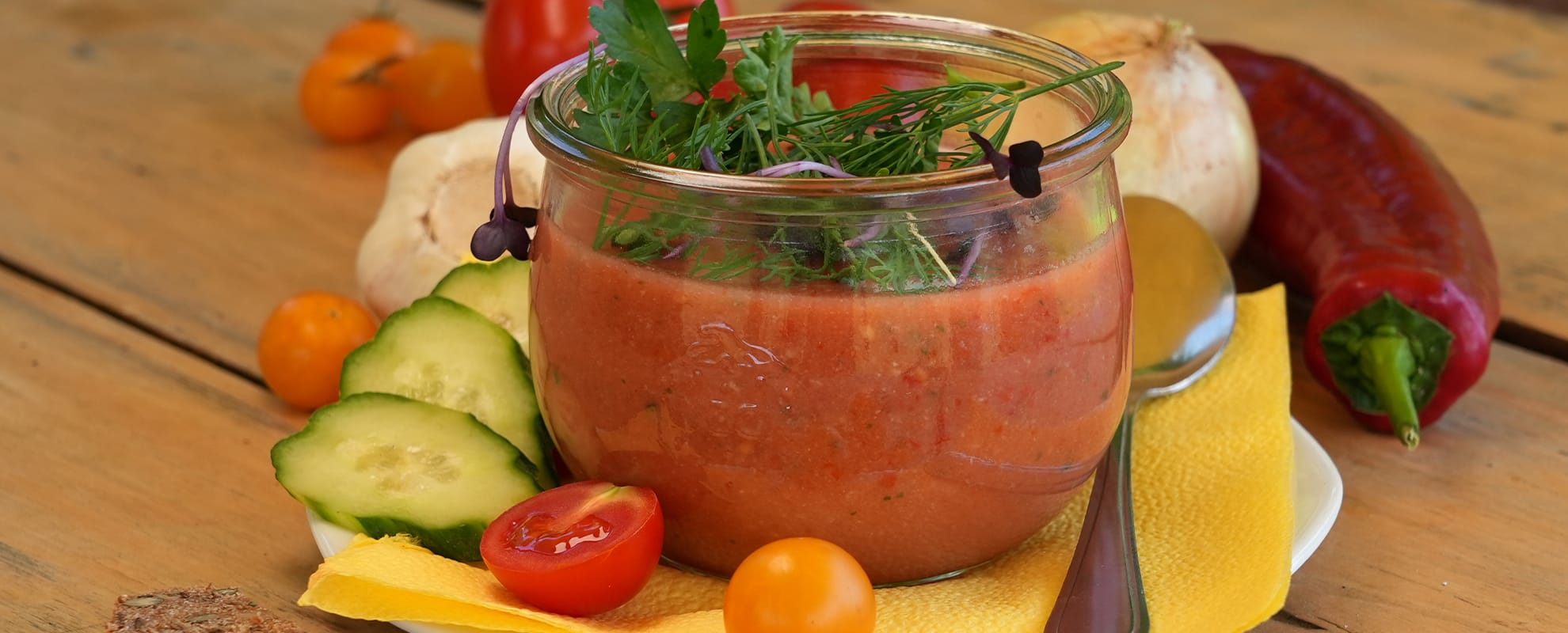 Ein Glas mit Gazpacho und Gemüse